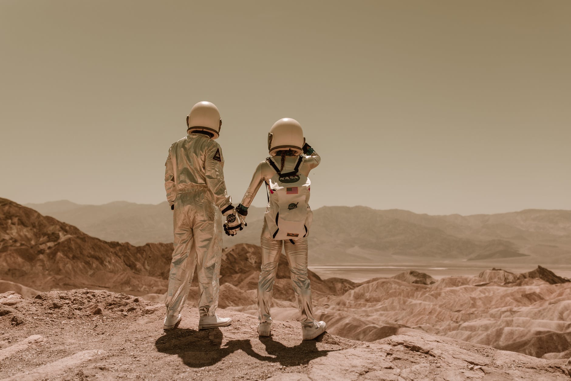 back view of astronauts holding hands